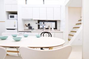 a white kitchen with a white table and chairs at Apartment J garden Myeongdong Station in Seoul