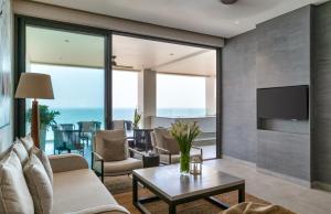 Crystal Sands - Hikkaduwa في هيكادوا: غرفة معيشة مع أريكة وتلفزيون