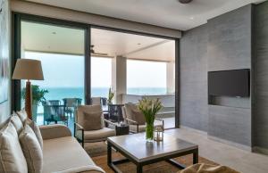 a living room with a couch and a tv at Crystal Sands - Hikkaduwa in Hikkaduwa