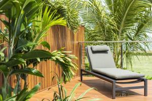 une chaise assise sur une terrasse avec des plantes dans l'établissement Indigo at Funnel Bay, à Airlie Beach