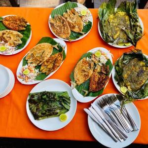 a group of plates of food on an orange table at Tranquility Cottage Resorts in Baga