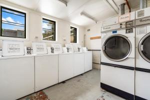 uma lavandaria com máquinas de lavar roupa e janelas em The Great Western Hotel em Orange