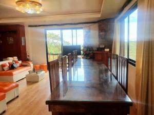 ein Wohnzimmer mit einem Tisch und ein Wohnzimmer mit einem Sofa in der Unterkunft The 3rd Floor Lot 16 Country Estates inside Camp John Hay- with view in Baguio City