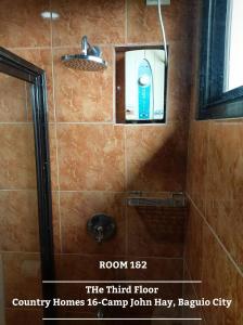 eine Dusche mit einer Flasche Seife in einer Duschkabine in der Unterkunft The 3rd Floor Lot 16 Country Estates inside Camp John Hay- with view in Baguio City