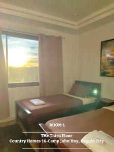 ein Hotelzimmer mit einem Bett und einem Fenster in der Unterkunft The 3rd Floor Lot 16 Country Estates inside Camp John Hay- with view in Baguio City
