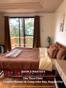 ein Schlafzimmer mit einem Bett und einem großen Fenster in der Unterkunft The 3rd Floor Lot 16 Country Estates inside Camp John Hay- with view in Baguio City