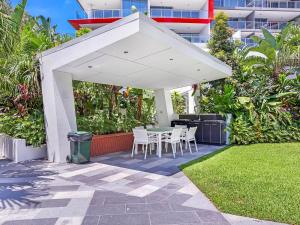 a patio with a table and chairs under a white canopy at Harbour Quays Apartments in Gold Coast