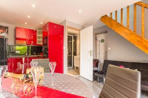 a kitchen and dining room with red cabinets and a table at Gite Les 3 S in Beaune