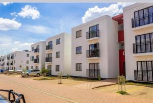 una fila de edificios de apartamentos blancos en una calle en La Maison II- Two Bedroom in Tatu City, Nairobi, en Nairobi