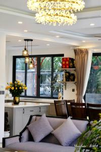 un salon avec un canapé et quelques fenêtres dans l'établissement Villa Mayfair B101 Đại Lải - 5 Phòng ngủ, à Thanh Cao