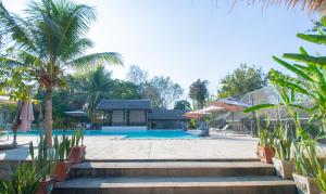 un complejo con piscina y palmeras en Luang Prabang chanon hotel, en Luang Prabang