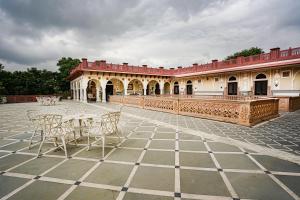 cortile con tavoli e sedie di fronte a un edificio di Khas Bagh a Jaipur