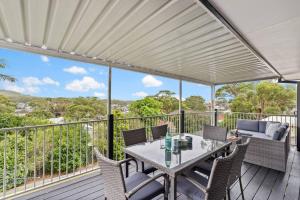 a patio with a table and chairs on a deck at The Wreck Room Holiday House close to the Beach with Ample Boat Parking in Shoal Bay