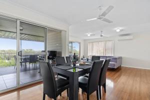 a dining room and living room with a table and chairs at The Wreck Room Holiday House close to the Beach with Ample Boat Parking in Shoal Bay