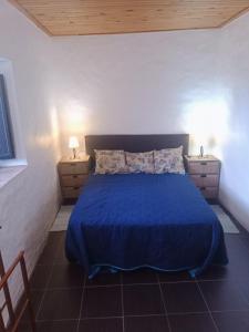 ein Schlafzimmer mit einem blauen Bett und zwei Nachttischen in der Unterkunft Casa Do Forno - Quinta Amoreira in Faro