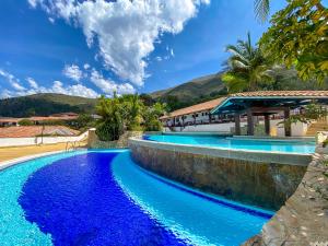 a pool with blue water in front of a house at Hospederia Centro de Convenciones Duruelo in Villa de Leyva