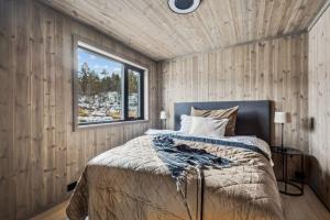 1 dormitorio con cama y ventana en Brand new cabin at Hovden cross-country skiing en Hovden