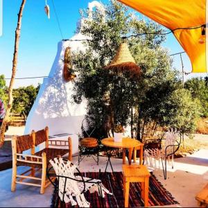 a patio with a table and chairs under a tent at Sublim' Ecolodge in Abela