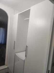 um armário branco com um espelho num quarto em Paris cosy private room with shared space - Chambre privée avec espace commun Paris em Vitry-sur-Seine