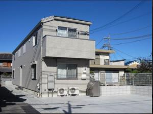 una casa con dos altavoces delante en メゾネットHIRAKU en Izumi-Sano