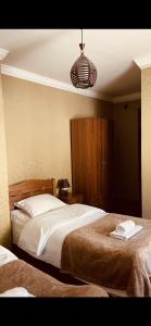 a bedroom with two beds and a light fixture at Guesthouse Chela in Mestia