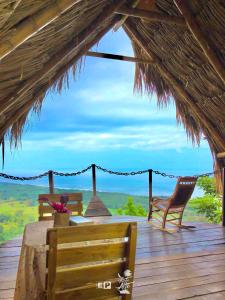 a table and chairs on a deck with a view at Puerto Alto in Santa Marta