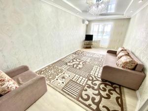 - un salon avec un canapé et un tapis dans l'établissement Апартаменты 2 комнатная в новом ЖК, à Aqtöbe