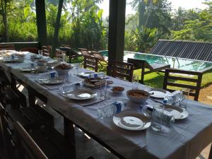 une grande table avec des assiettes et des bols de nourriture dans l'établissement Rainforest Chalets - Rainforest Tours,Pool And Ac, à Deniyaya
