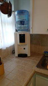 a small refrigerator with a water container on top of it at Lynn's Cozy Cottage in Nassau