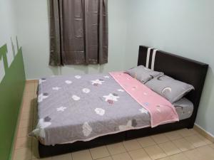 1 dormitorio con 1 cama con edredón gris en QQ Homestay en Ipoh