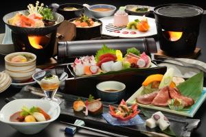 una mesa cubierta con diferentes tipos de sushi y comida en Yumoto Kissho, en Osaki