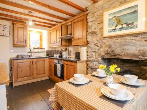 a kitchen with a table and a stone fireplace at Ty Mawr in Blaenau-Ffestiniog