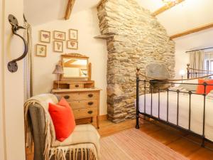 a bedroom with a bed and a stone wall at Ty Mawr in Blaenau-Ffestiniog