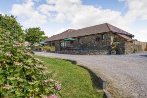 a stone house with a gravel road in front of it at The Dairy in Llanmorlais