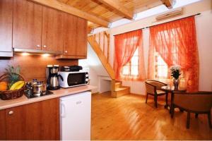 cocina y comedor con mesa y microondas en Irene Maisonettes, en La Canea