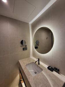 uma casa de banho com um lavatório e um espelho em The Marevo em Suwon