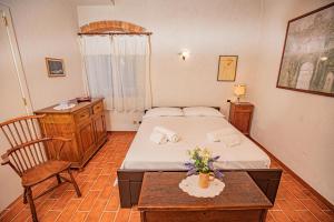 a bedroom with a bed and a chair and a table at Affitti Brevi Toscana - A due passi dal Mare in Magliano in Toscana