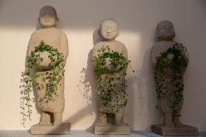 Villa L3 by Stay Samui - Bohemian Chic في كوه ساموي: مجموعة من ثلاثة تماثيل حجرية تمسك النباتات