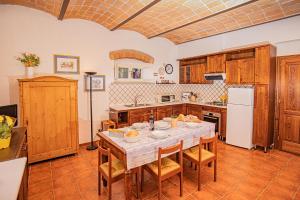 a kitchen with a table and chairs in a room at Affitti Brevi Toscana - A due passi dal Mare in Magliano in Toscana