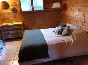 um quarto com uma cama num chalé de madeira em Chalet Bois Cosy em Ferdrupt