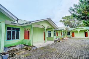 eine Reihe grüner Häuser mit Auffahrt in der Unterkunft OYO 92239 Taman Wisata Iman I in Hutamanik