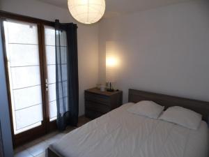 ein Schlafzimmer mit einem Bett und einem großen Fenster in der Unterkunft Appartement Marseillan-Plage, 2 pièces, 4 personnes - FR-1-326-538 in Marseillan