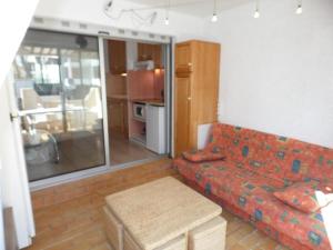 ein Wohnzimmer mit einem Sofa und einer Küche in der Unterkunft Appartement Marseillan-Plage, 2 pièces, 4 personnes - FR-1-326-538 in Marseillan