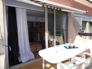 einen weißen Tisch und Stühle auf dem Balkon in der Unterkunft Appartement Marseillan-Plage, 2 pièces, 4 personnes - FR-1-326-538 in Marseillan