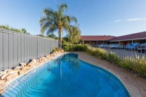 a swimming pool in a yard next to a fence at Best Western Ambassador Motor Inn & Apartments in Wagga Wagga