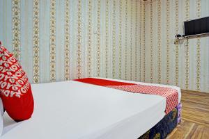 1 dormitorio con 1 cama con manta roja en OYO 92240 Taman Wisata Iman Ii, en Hutamanik