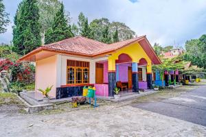 una casa pequeña y colorida al lado de una calle en OYO 92240 Taman Wisata Iman Ii, en Hutamanik