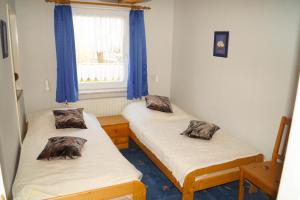 two twin beds in a room with a window at Ferienwohnungen Tietgen in Katharinenhof