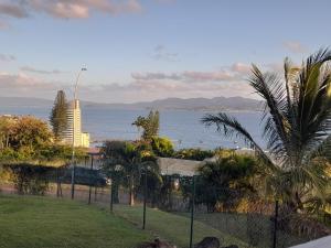- une vue sur l'océan avec une clôture et des palmiers dans l'établissement BaySide, à Fort-de-France
