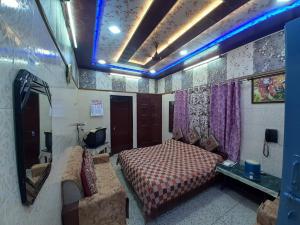 a bedroom with a bed and a couch in a room at Jagan Hotel & Restaurant in Dhaulpur